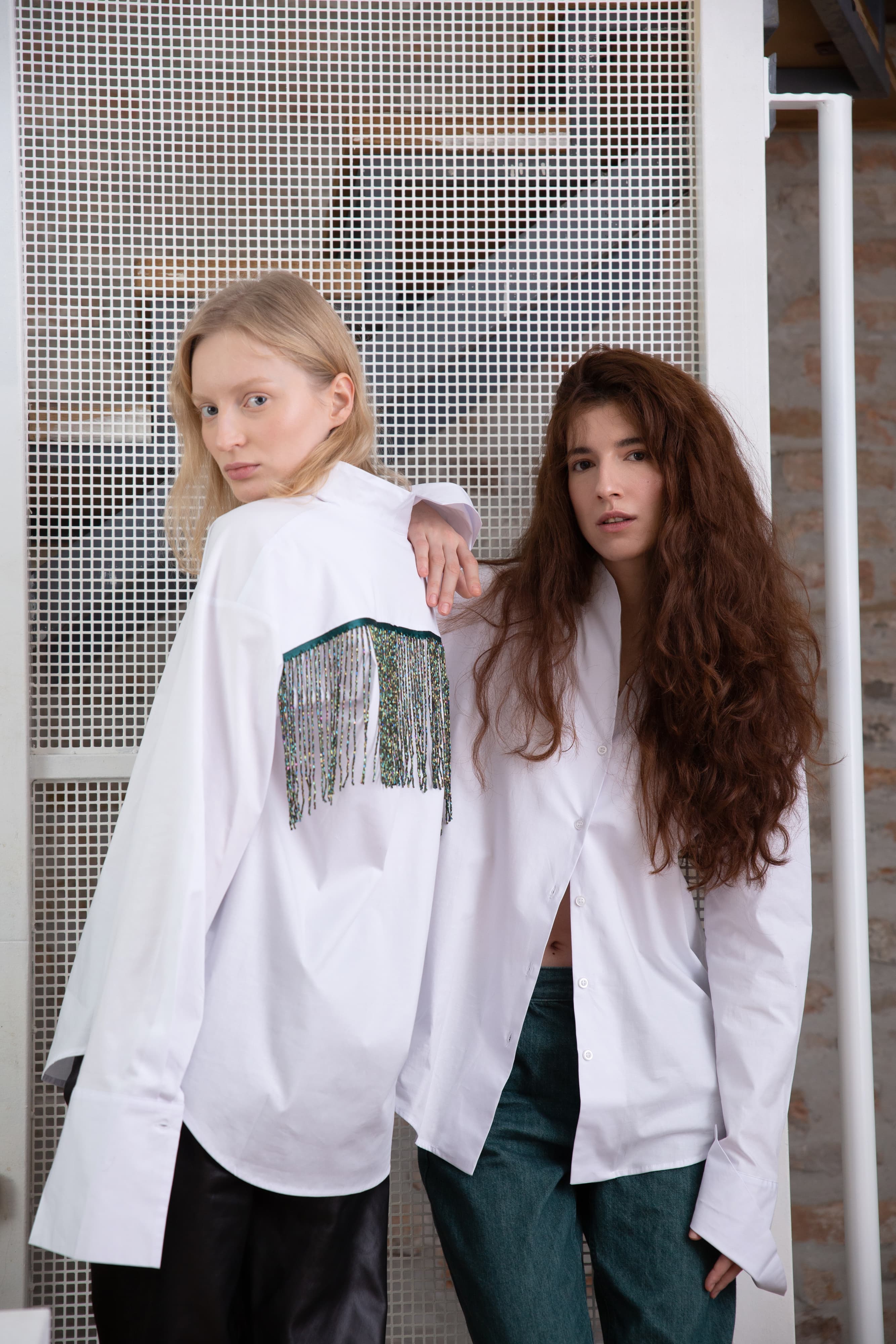 A wide-fit collared shirt featuring elongated cuffs and a distinctive touch of style – a glass beaded fringe adorning the back. This unique piece effortlessly combines comfort with a hint of flair, making it a standout choice for various occasions.